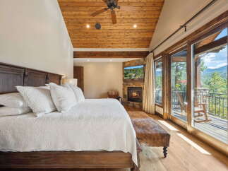 Experience luxury in this stunning bedroom featuring a cozy fireplace and a breathtaking view.