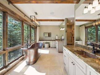 Indulge in luxury within this stunning bathroom, featuring a unique copper bathtub and expansive windows that frame breathtaking views.