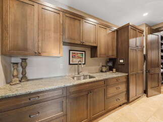 This stunning kitchen boasts custom cabinetry, granite countertops, and a stainless steel sink, perfect for culinary enthusiasts.