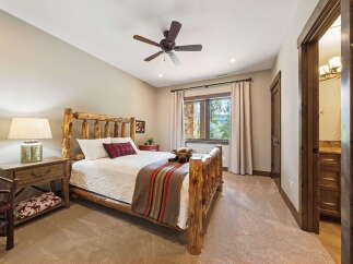 This cozy bedroom features a rustic log bed frame, creating a warm and inviting atmosphere.