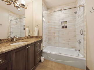 Step into luxury with this stunning bathroom! Featuring a sleek glass shower enclosure, a beautiful vanity with ample storage, and elegant fixtures, this space is designed for both style and functionality.