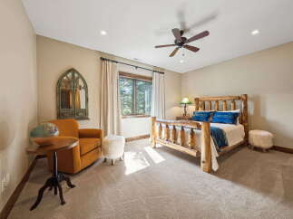 This stunning bedroom boasts a rustic charm with its wooden bed frame and cozy seating area.