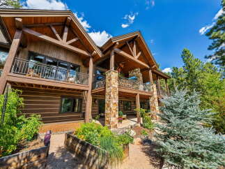 This stunning property boasts a beautiful exterior with a combination of wood and stone elements, creating a warm and inviting atmosphere.