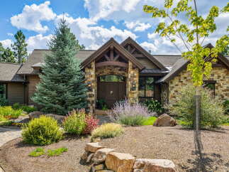 This stunning property boasts a beautiful stone facade and a welcoming wooden door, creating an inviting first impression.