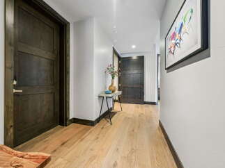 Step into this stunning entryway, showcasing beautiful hardwood floors and dark wood doors.