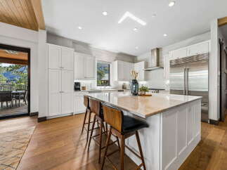 This stunning kitchen boasts a modern design with sleek white cabinetry and a spacious island, perfect for both cooking and entertaining.