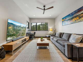 This stunning living room boasts a modern design with a large flat-screen TV and a stylish wooden entertainment unit.