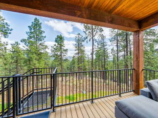 Enjoy breathtaking views from this stunning property featuring a spacious deck and a comfortable outdoor seating area.