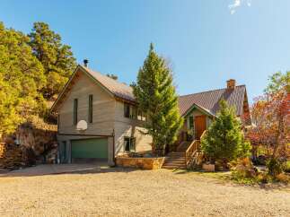 Nestled amidst the serene landscape, this stunning property boasts a charming exterior with a rustic appeal.