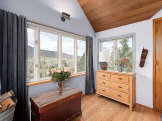 This charming room features a cozy ambiance with a wooden ceiling and hardwood floors.