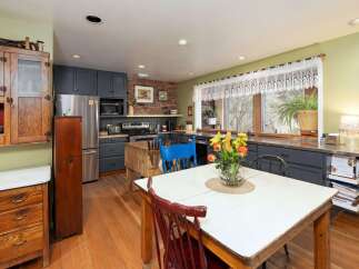This charming kitchen boasts a rustic aesthetic with its exposed brick wall and wooden cabinetry.