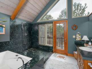 This stunning bathroom boasts a luxurious design with a marble shower and a relaxing bathtub.