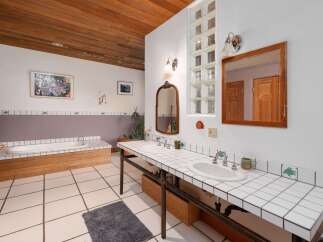 This unique bathroom features a blend of rustic and artistic elements.