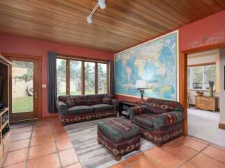 Step into this inviting living space, featuring a cozy sofa, armchair, and ottoman set, perfect for relaxation.