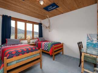 This charming bedroom features two twin beds with colorful bedding, perfect for guests or children.