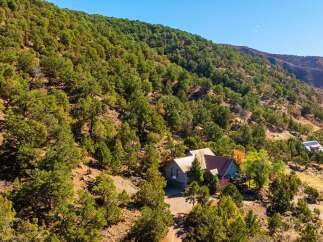 Nestled in a serene, tree-covered hillside, this property offers a unique blend of privacy and natural beauty.