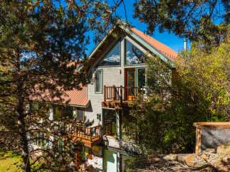 Nestled amidst lush greenery, this stunning property boasts a unique architectural design with a charming balcony.