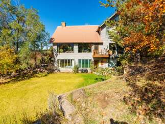 Nestled amidst lush greenery, this stunning property boasts a charming exterior with a warm, inviting ambiance.