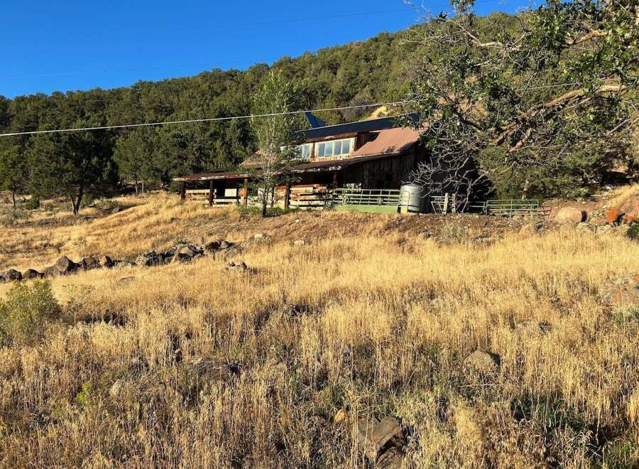 Discover this rustic cabin nestled on a hillside, offering a unique blend of natural beauty and secluded living.