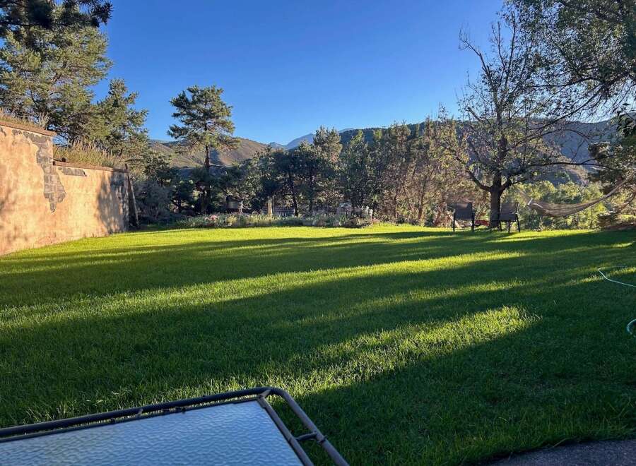 Enjoy the serene beauty of this property with a lush green lawn perfect for outdoor activities.