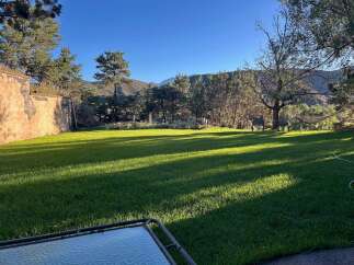 Enjoy the serene beauty of this property with a lush green lawn perfect for outdoor activities.