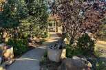Discover a charming pathway leading to a rustic wooden pergola, perfect for outdoor gatherings.