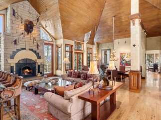 Experience luxury living in this stunning property featuring a grand stone fireplace, perfect for cozy evenings.