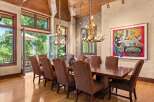Experience elegant dining in this spacious room featuring a large wooden table surrounded by upholstered chairs.