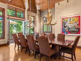 Experience elegant dining in this spacious room featuring a large wooden table surrounded by upholstered chairs.