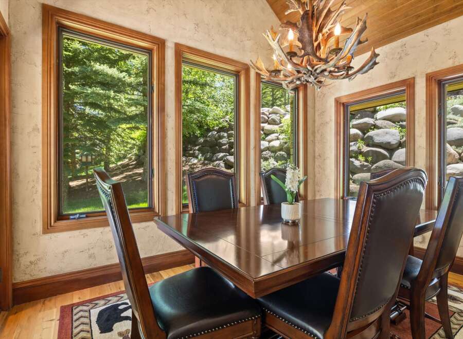 Experience elegant dining in this beautifully appointed room, featuring a rich mahogany table surrounded by plush leather chairs.