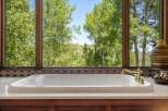 Indulge in ultimate relaxation with this luxurious soaking tub, perfectly positioned to offer breathtaking views of the surrounding lush greenery and rolling hills.