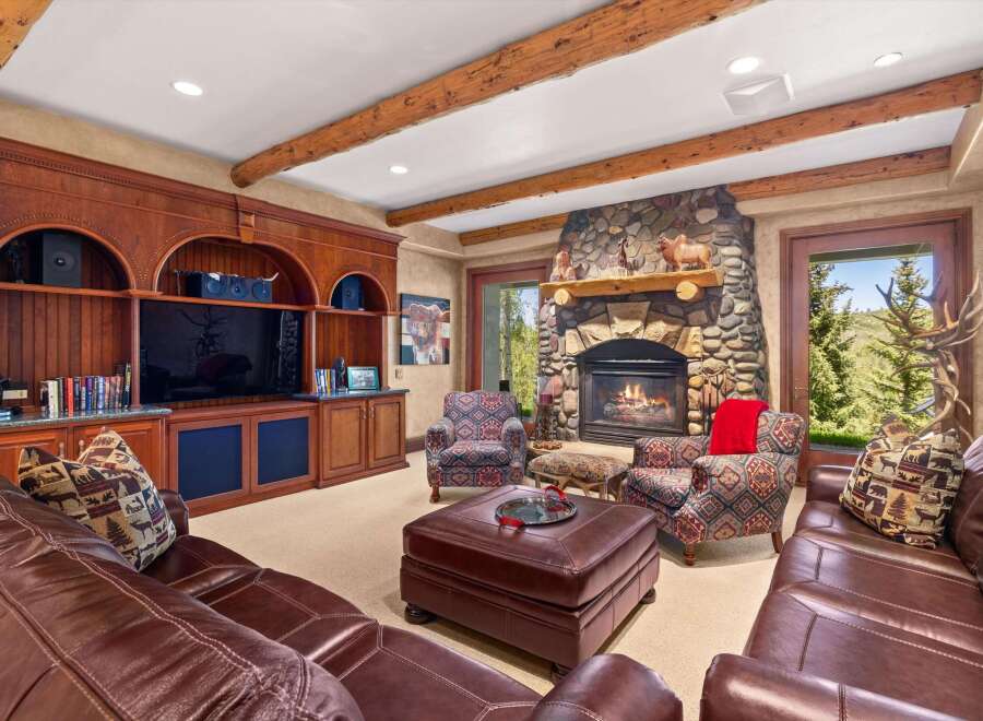 Experience rustic elegance in this inviting living room, featuring a grand stone fireplace and rich wood built-ins.