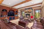 Experience rustic elegance in this inviting living room, featuring a grand stone fireplace and rich wood built-ins.