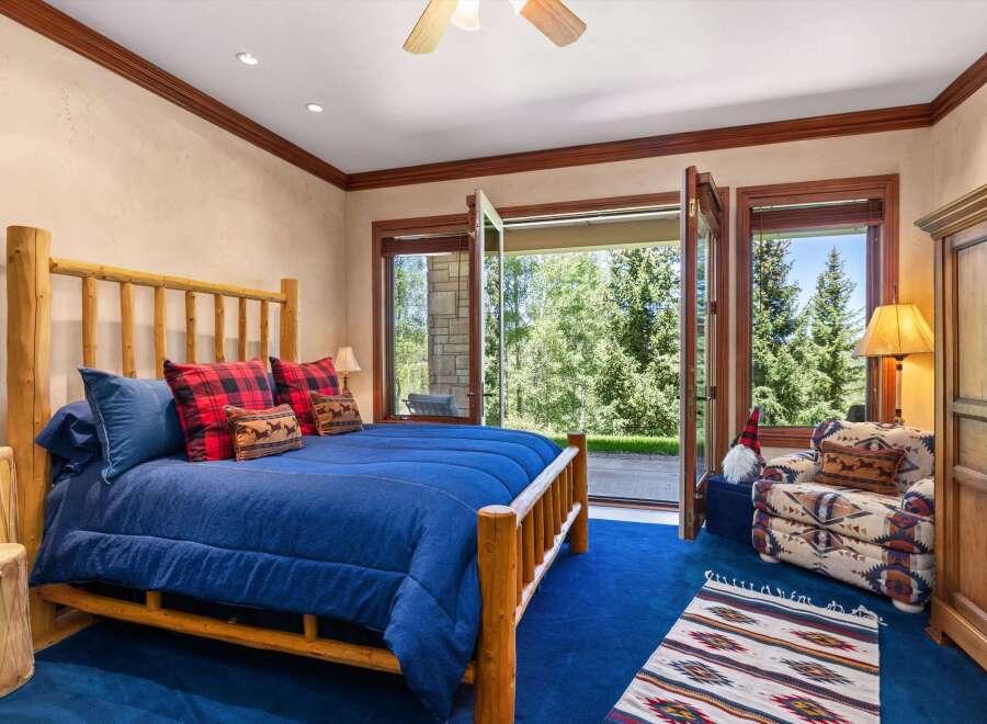 Experience rustic charm in this inviting bedroom, featuring a sturdy log bed and cozy plaid accents.