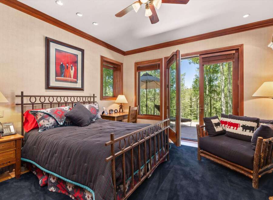 Experience rustic elegance in this charming bedroom, featuring a wrought-iron bed and a cozy seating area.