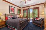 Experience rustic elegance in this charming bedroom, featuring a wrought-iron bed and a cozy seating area.