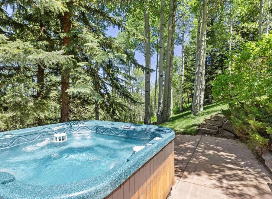 Indulge in ultimate relaxation with this luxurious hot tub, perfectly situated amidst a serene forest setting.