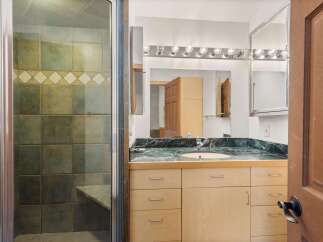 Step into a luxurious bathroom featuring a sleek vanity with ample storage and a stunning marble countertop.