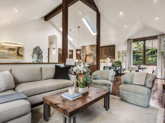 Experience luxury living in this stunning property featuring a spacious living room with high ceilings and a cozy fireplace.