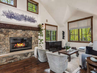 This stunning living room boasts a cozy fireplace with a stone facade, perfect for chilly evenings.