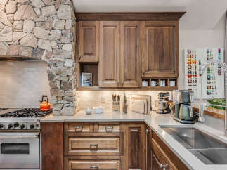 This stunning kitchen boasts a unique stone accent wall, adding a touch of rustic elegance to the space.