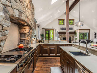 This stunning kitchen boasts a unique stone wall, adding a touch of rustic elegance to the space.