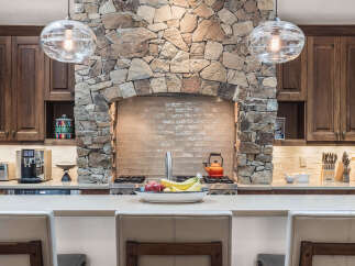 This stunning kitchen boasts a unique stone accent wall, creating a warm and inviting atmosphere.