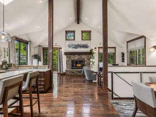 This stunning property boasts a spacious open-concept living area with a cozy fireplace, perfect for gatherings.