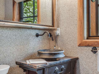 Discover the rustic charm of this bathroom, featuring a unique sink and a vintage-style vanity.
