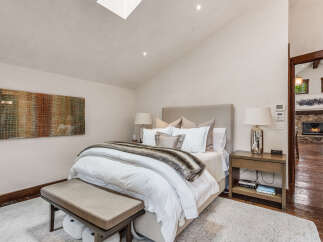 Step into luxury with this stunning bedroom, featuring a plush bed adorned with elegant bedding and a cozy fur throw.
