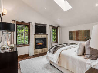 This luxurious bedroom boasts a cozy fireplace, perfect for chilly evenings.