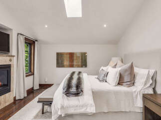 Experience luxury in this stunning bedroom featuring a cozy fireplace, perfect for chilly evenings.