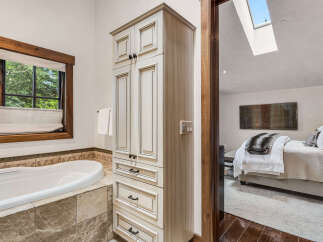 Step into luxury with this stunning bathroom, featuring a serene soaking tub and elegant cabinetry.