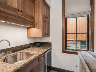This stunning kitchen features custom cabinetry, a granite countertop, and a stainless steel sink.
